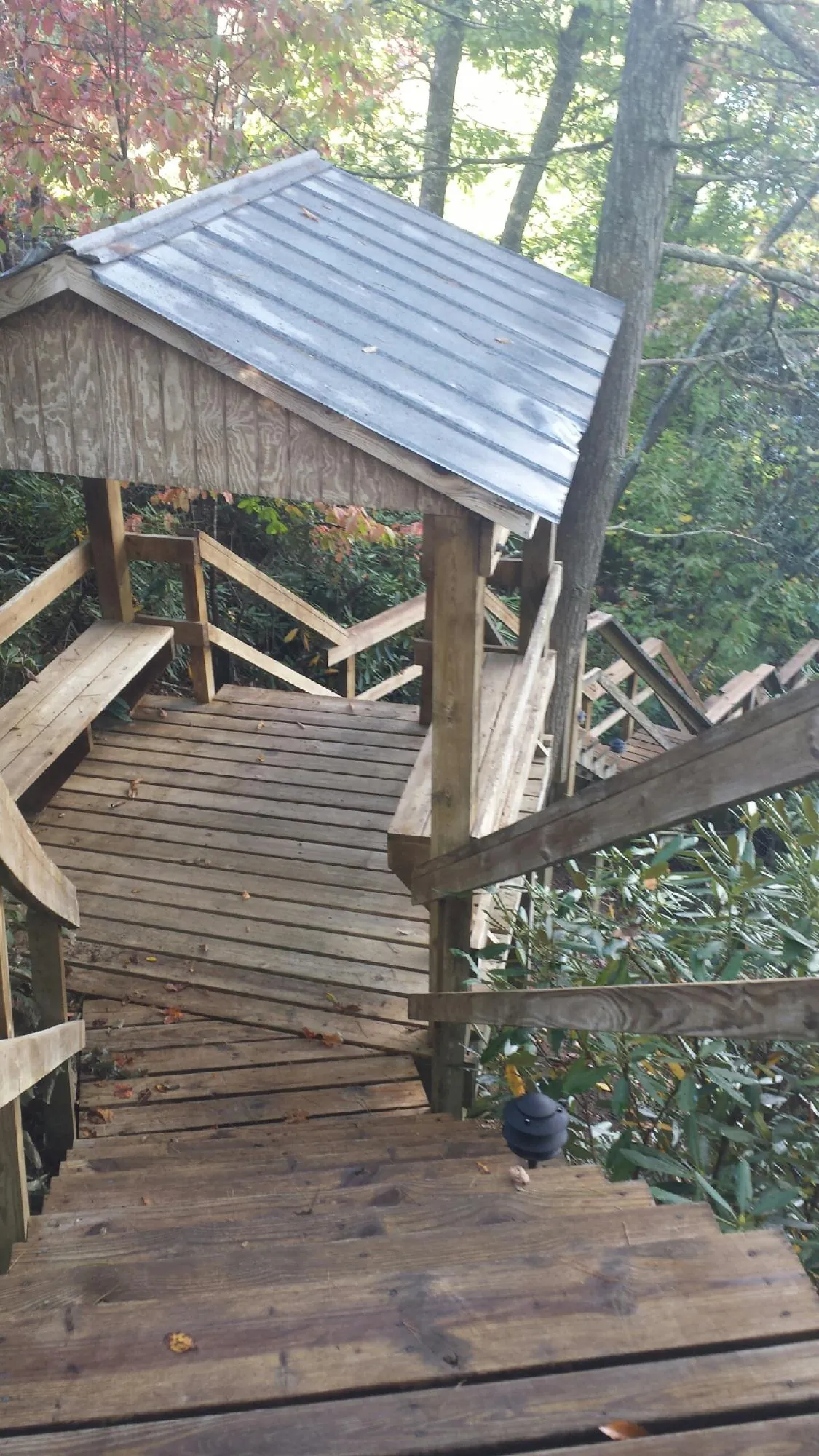 Metal roofed shelter over wooden steps on a wooded walkway — Skylight Repair & Installation work by our crew in Avon